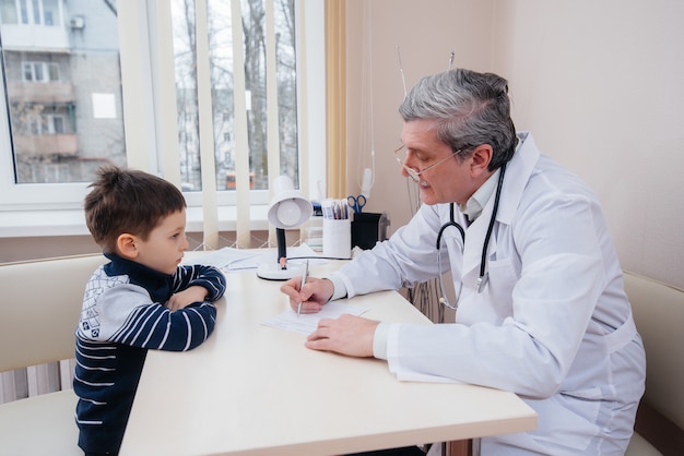 Een jonge jongen wordt beluisterd en behandeld door een ervaren arts in een moderne kliniek. Een virus en een epidemie