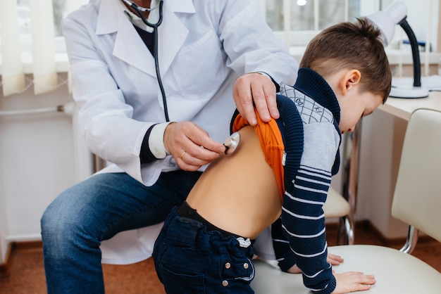 Een jonge jongen wordt beluisterd en behandeld door een ervaren arts in een moderne kliniek. Een virus en een epidemie