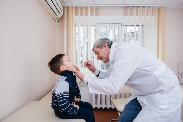 Een jonge jongen wordt beluisterd en behandeld door een ervaren arts in een moderne kliniek