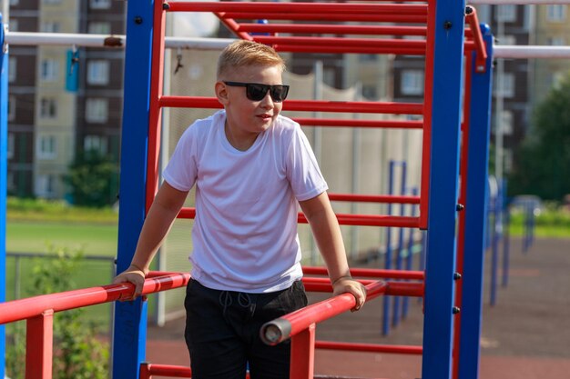 Een jonge kerel doet push-ups op bars op een sportveld in de zomer. Hoge kwaliteit foto