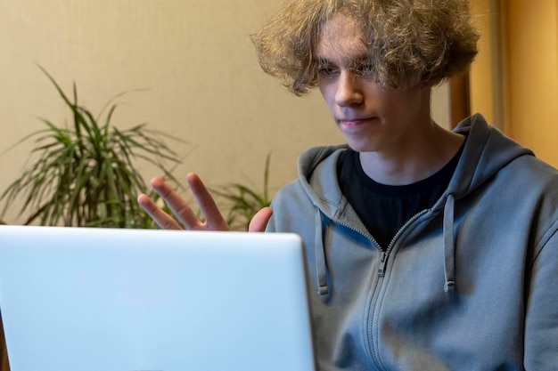 Een jonge kerel is aan het chatten in een videochat via een laptop-videogesprek
