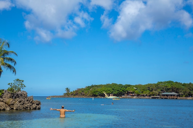 Een jonge man die de Caribische Zee binnengaat bij West End Beach op Roatan Island. Honduras