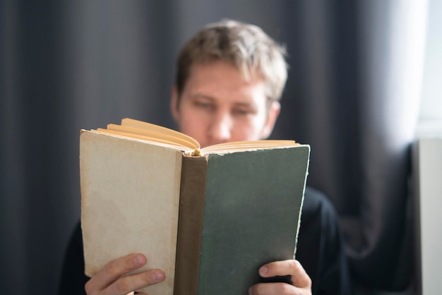 Een jonge man die het boek leest thuis student huiswerk