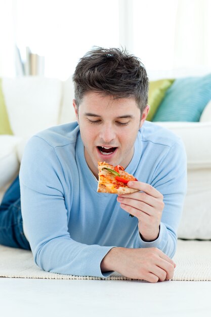 Een jonge man die pizza eet