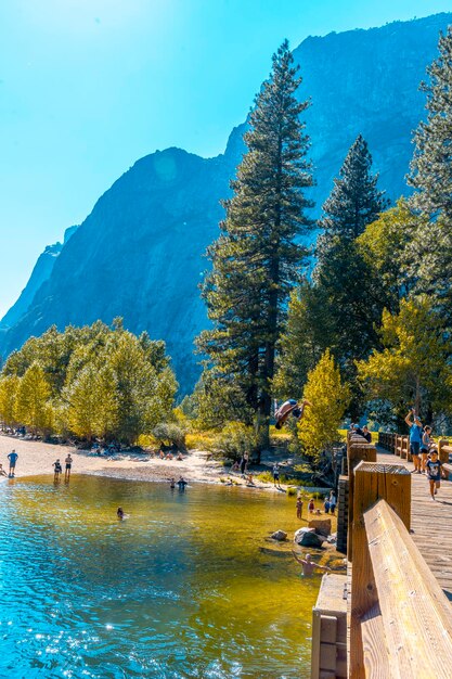 Een jonge man die zichzelf in het water gooit bij de Swinging Bridge Yosemite Valley