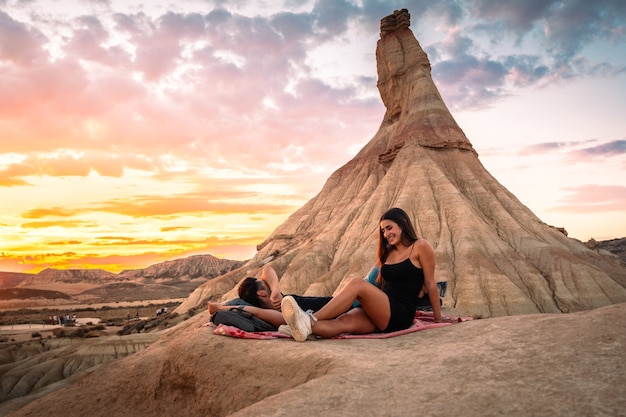 Een jonge man en een jonge vrouw kijken naar de zonsondergang bij Castildetierra in de woestijn van Bardenas Reales, Navarra, Baskenland.