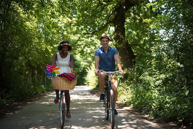 een jonge man en een mooi Afro-Amerikaans meisje genieten van een fietstocht in de natuur op een zonnige zomerdag