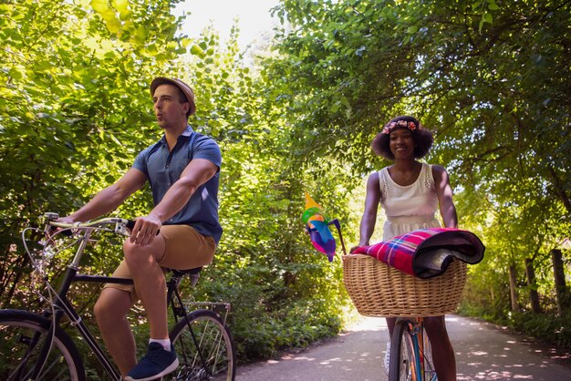 een jonge man en een mooi Afro-Amerikaans meisje genieten van een fietstocht in de natuur op een zonnige zomerdag