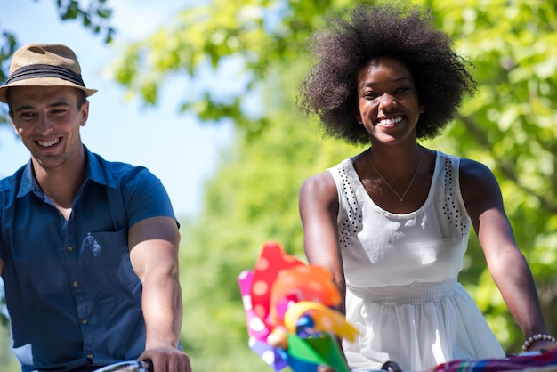 een jonge man en een mooi Afro-Amerikaans meisje genieten van een fietstocht in de natuur op een zonnige zomerdag