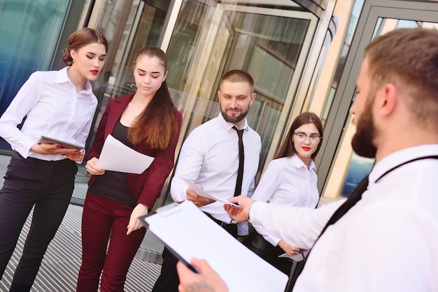 Een jonge man geeft blanco vellen papier uit aan mensen. ter discussie stellen. opiniepeiling