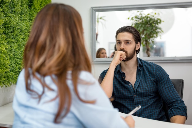 Een jonge man geeft een sollicitatiegesprek en de gegevens worden door een jonge vrouw verzameld.