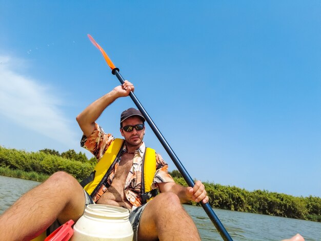 Een jonge man in de kano die kanoën in het natuurpark van catalonië, rivier naast het strand in estartit