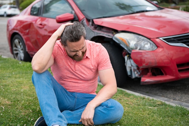 Een jonge man in wanhoop greep zijn hoofd vast auto kapot op de weg