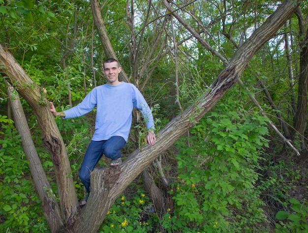 Een jonge man klom in de natuur in een wilg