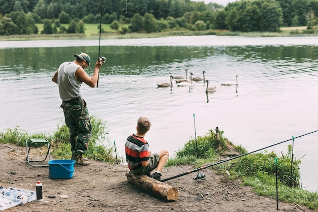 Een jonge man leert zijn kinderen vissen tijdens een gezinsvakantie op een kampeerplaats