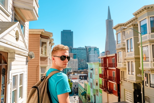 Een jonge man loopt door een prachtige straat met uitzicht op de Transamerica Tower in San Francisco