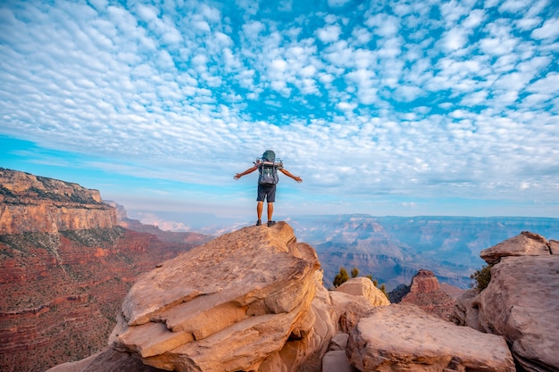 Een jonge man met open armen op een uitzichtpunt van de afdaling van de South Kaibab Trailhead. Grand Canyon, Arizona