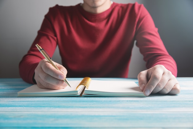 Een jonge man schrijft in een notitieboekje