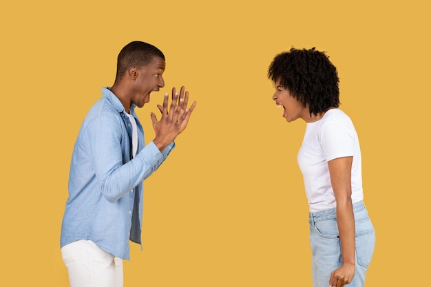 Een jonge man schrikt terug met zijn handen omhoog terwijl een jonge vrouw woedend naar hem schreeuwt