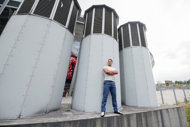 Een jonge man staat in de open lucht bij technische constructies