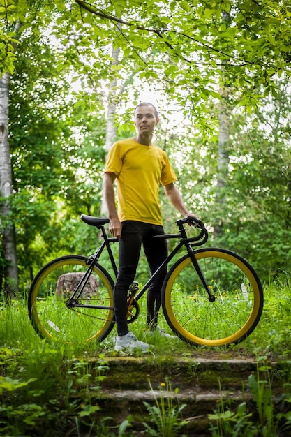 Een jonge man stopte om te rusten met zijn fiets in een openbaar park