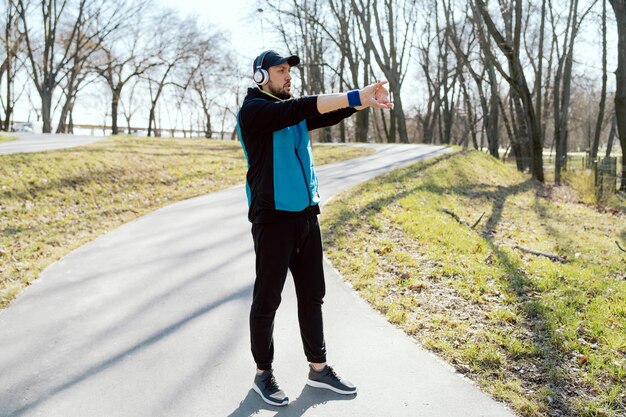 Een jonge man traint in een openbaar park en luistert naar motiverende hardloopmuziek