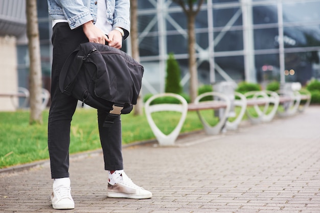 Een jonge man wacht op een passagier op de luchthaven.