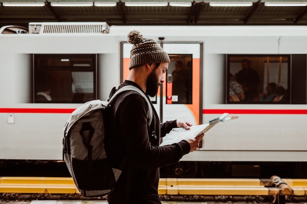 Een jonge man wacht op het treinstation