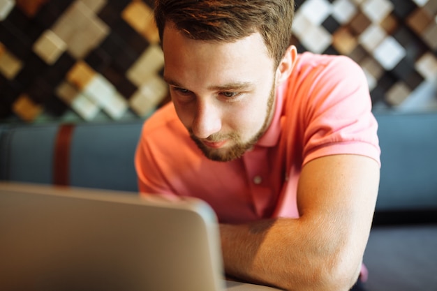 Foto een jonge man zit in een café met een laptop, werken, online winkelen, hipster