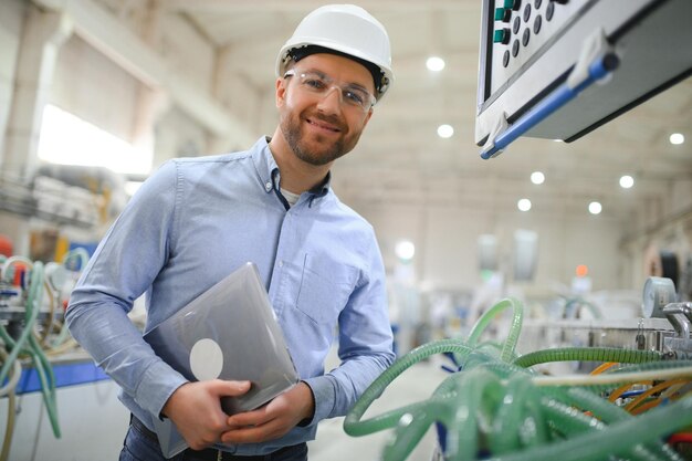 Foto een jonge mannelijke ingenieur inspecteert de productie van plastic vensterframes