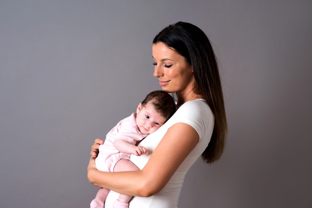 Een jonge moeder die haar baby in haar armen