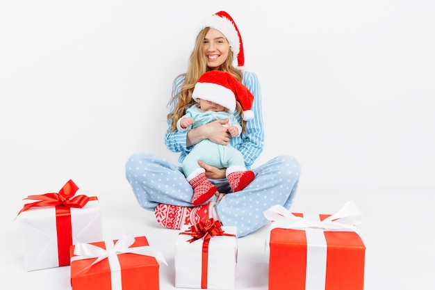 Foto een jonge moeder geeft op eerste kerstdag een geschenk aan een pasgeboren kind