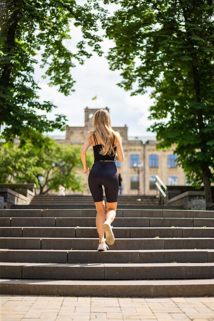 Een jonge mooie blonde vrouw met een sportieve lichaamsbouw in een zwart T-shirt