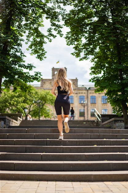 Een jonge mooie blonde vrouw met een sportieve lichaamsbouw in een zwart T-shirt