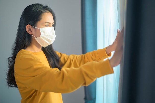 Een jonge mooie vrouw die een beschermend gezichtsmasker draagt dat zich klaar maakt om naar buiten te gaan, Gezondheidszorg en covid-19-concept