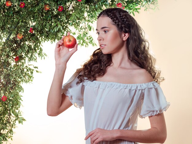 Een jonge mooie vrouw in de tuin van eden proeft een rijpe vrucht