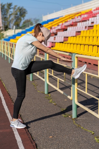 Een jonge mooie vrouw in sportkleding sport in een plaatselijk stadion