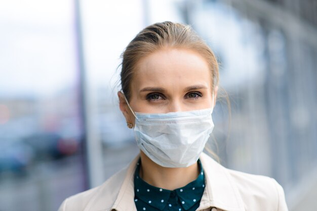 Een jonge onderneemster die een gezondheidsmasker draagt in de stad