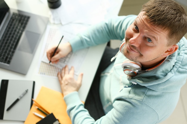 Een jonge ontwerper houdt een pen van een tablet in de zijne