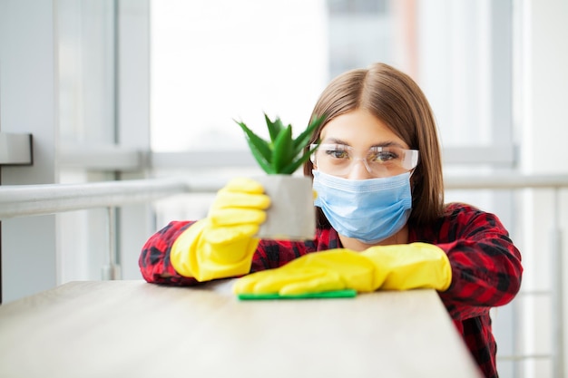 Een jonge professionele schoonmaakster maakt een modern kantoor schoon