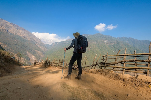 Een jonge reiziger die op bospad nepal trekt