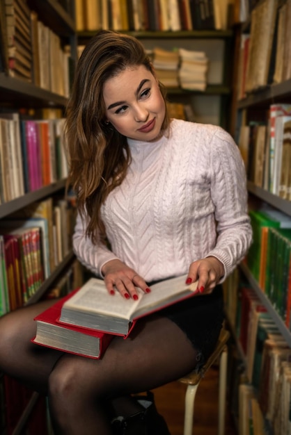 Een jonge slimme student studeert nuttig en interessant in een prachtige oude bibliotheek
