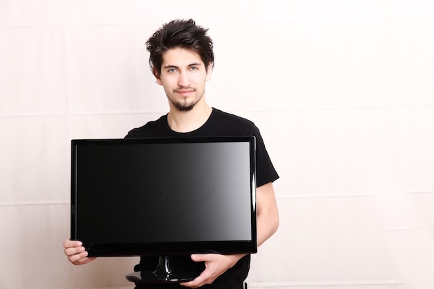 Foto een jonge spaanse man met een flatscreen-tv.