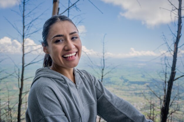 Een jonge Spaanse vrouw zittend op een rots en genietend van de prachtige natuur