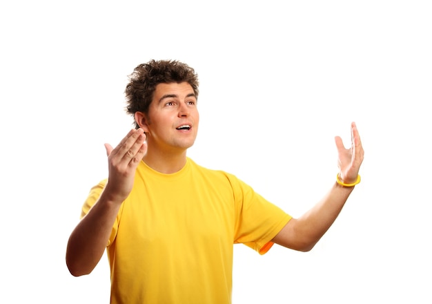 een jonge succesvolle man die tegen een witte achtergrond staat in een geel t-shirt met zijn armen omhoog