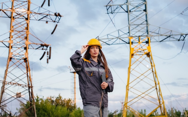 Een jonge technische werker inspecteert en controleert de uitrusting van de hoogspanningslijn. energie.