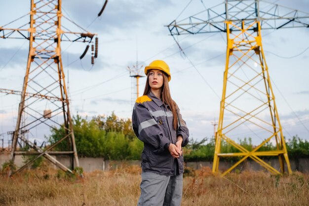 Een jonge technische werknemer inspecteert en controleert de uitrusting van de hoogspanningslijn. Energie.