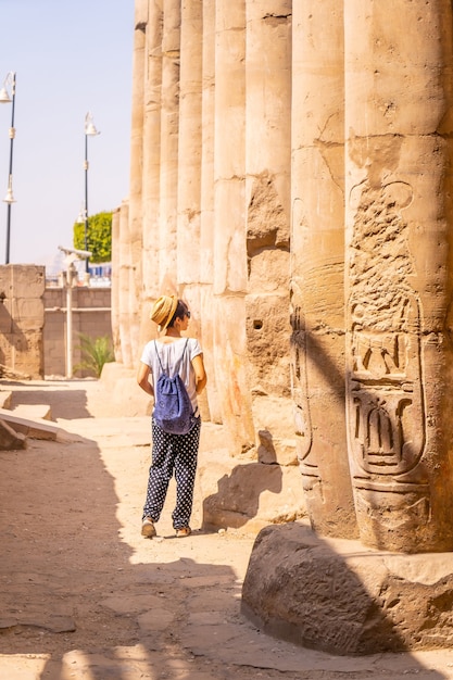 Een jonge toerist die de tempel bezoekt en de tekeningen in luxor-tempel, egypte bekijkt