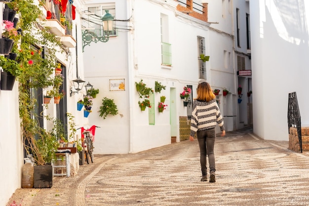 Een jonge toerist die door de witte huizen van de stad Nerja . loopt