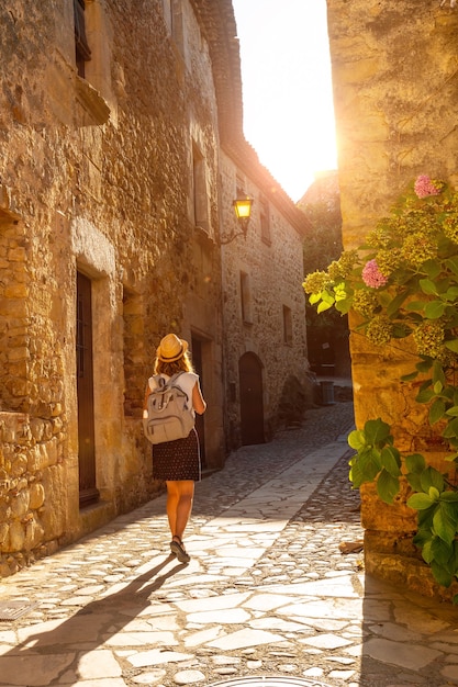 Een jonge toerist die in de middeleeuwse stad Pals loopt, straten van het historische centrum bij zonsondergang, Girona aan de Costa Brava van Catalonië in de Middellandse Zee